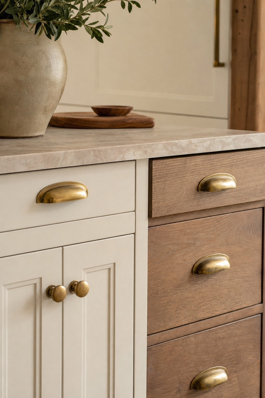 Aged brass hardware on creamy modern farmhouse kitchen cabinets