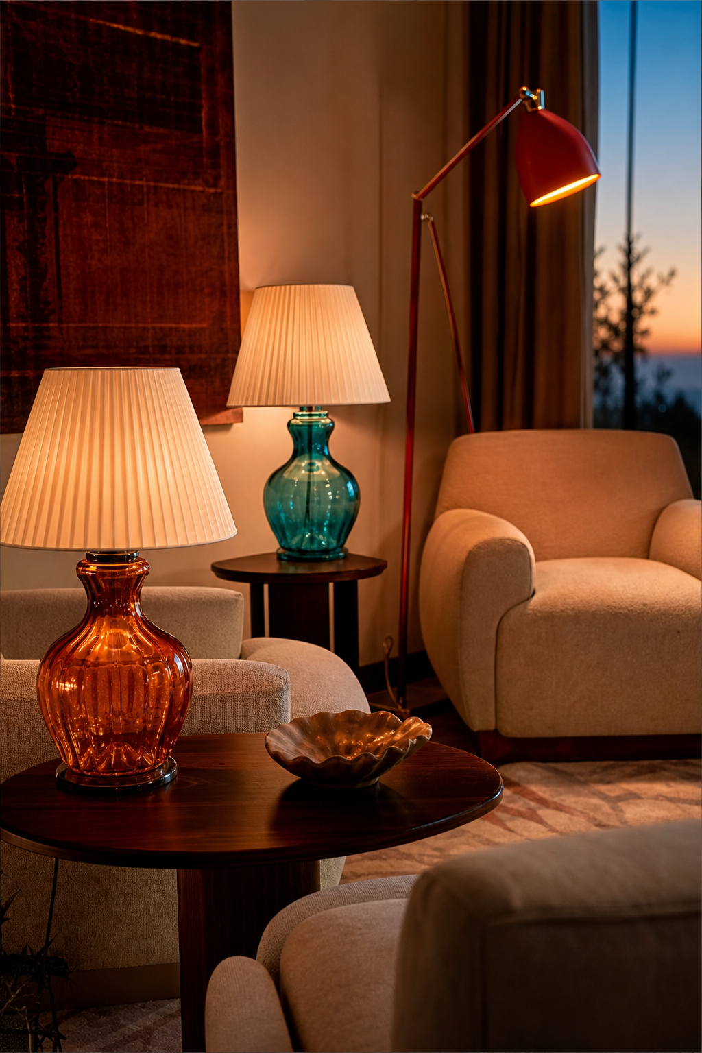 Sophisticated sitting room with sculptural colored glass lamps, cream armchairs, and warm layered lighting